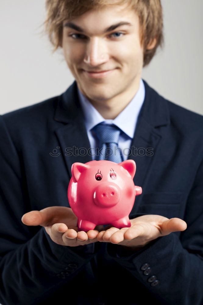 Similar – Unhappy man angry at his piggy bank