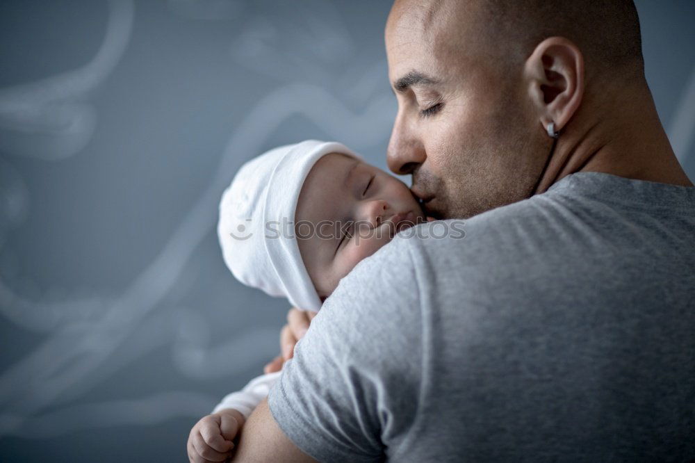 Similar – Image, Stock Photo Couple embracing and looking to their newborn over dark background