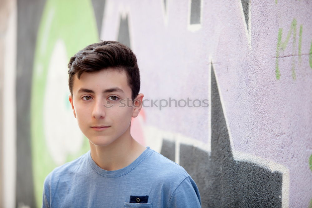 Similar – Portrait of a teenager with hoodie, in front of a red brick wall