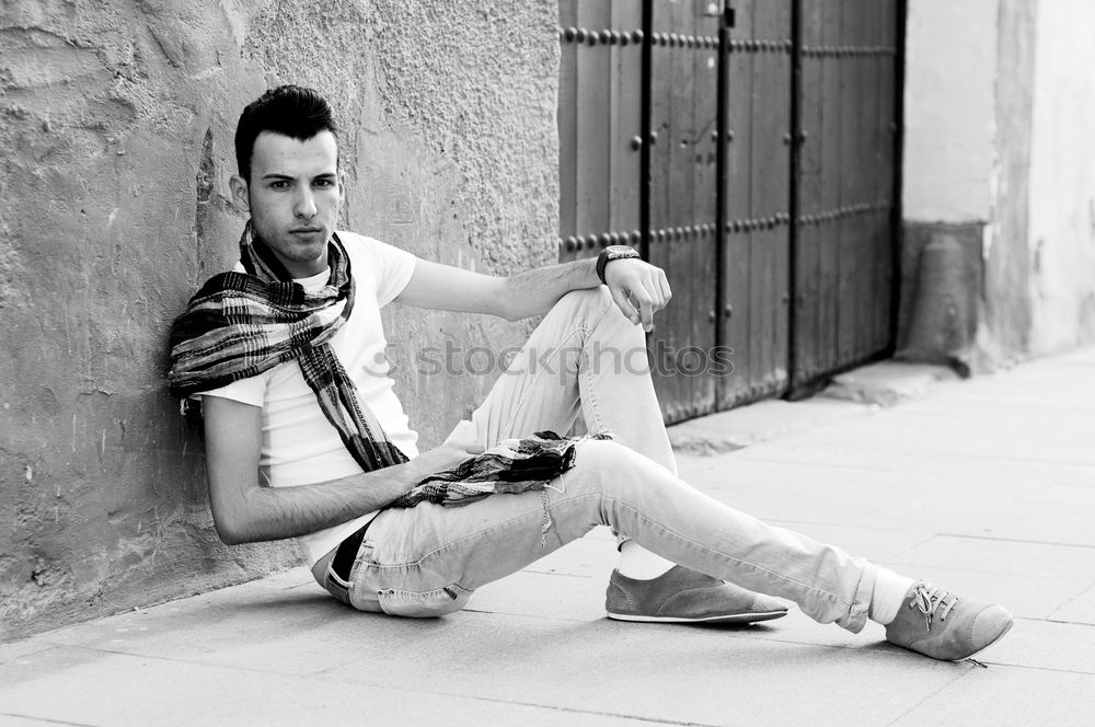 Similar – Young man with modern hairstyle sitting on stairs