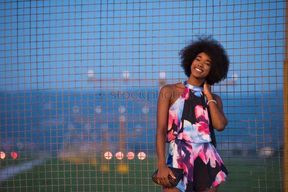 Woman with afro hair climbing by children’s attractions.