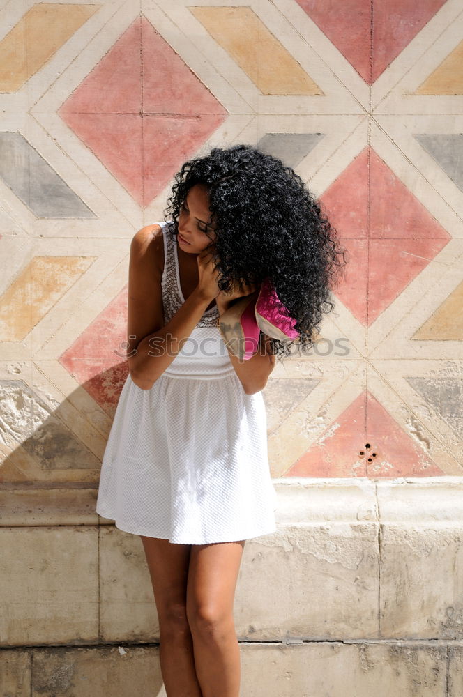 black woman, afro hairstyle, getting dressed in the street