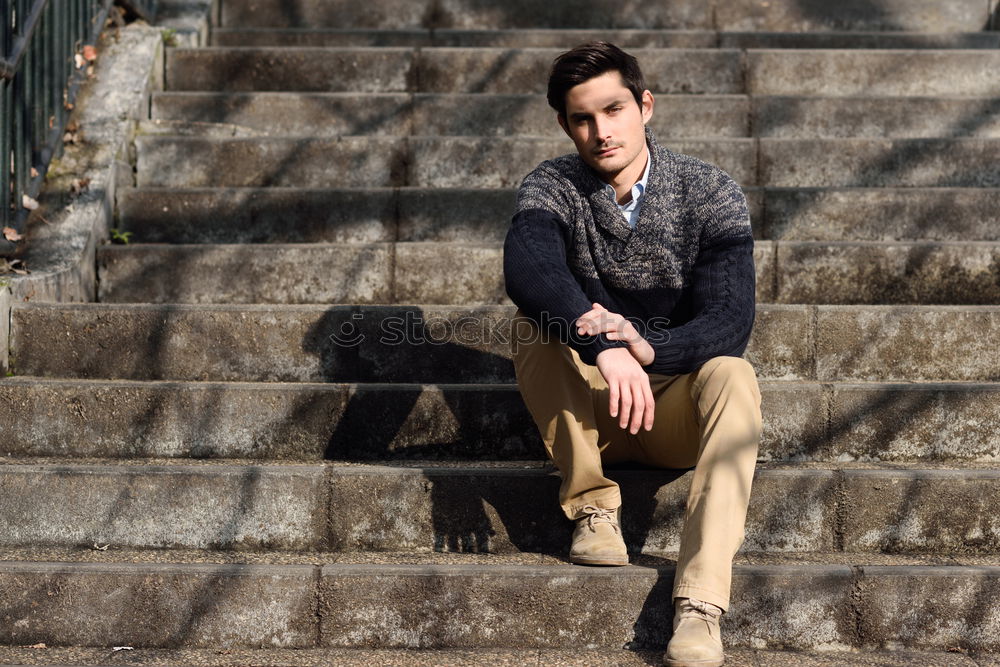 Similar – Young man with modern hairstyle sitting on stairs