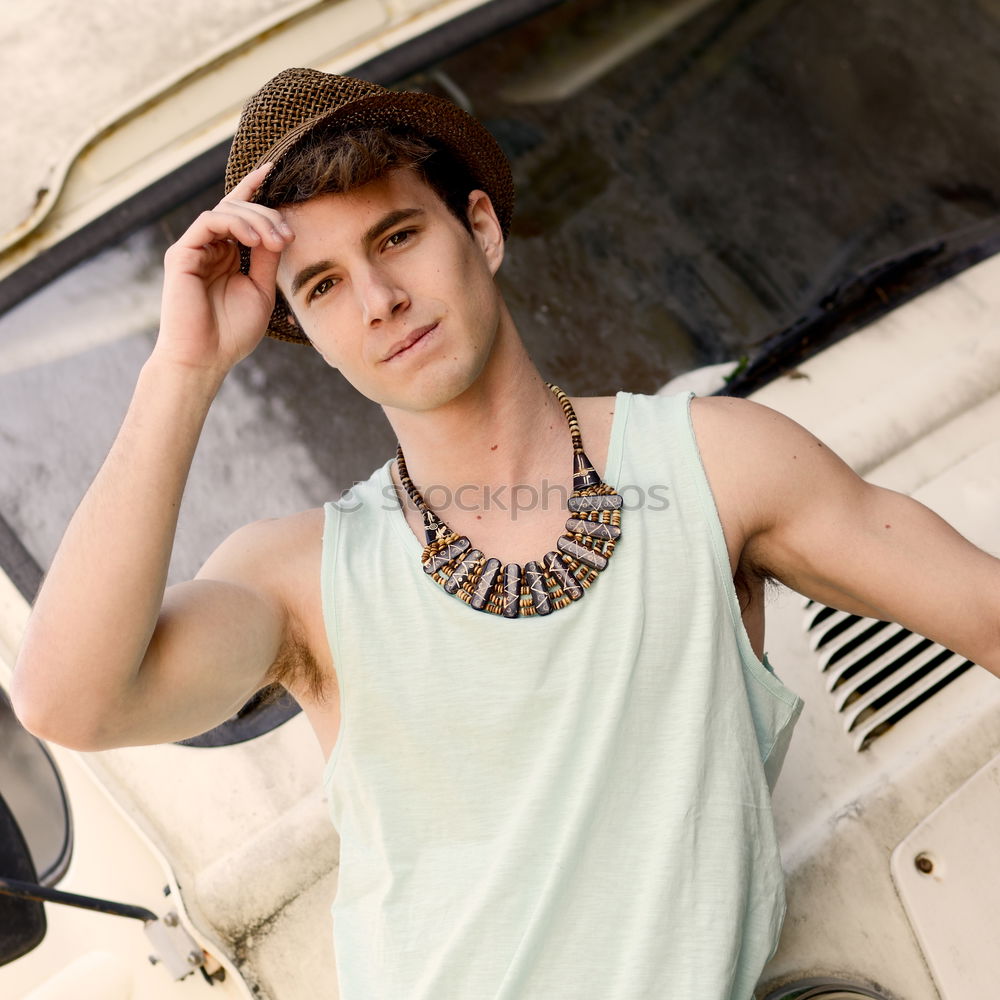 Young man with an old van wearing a sun hat