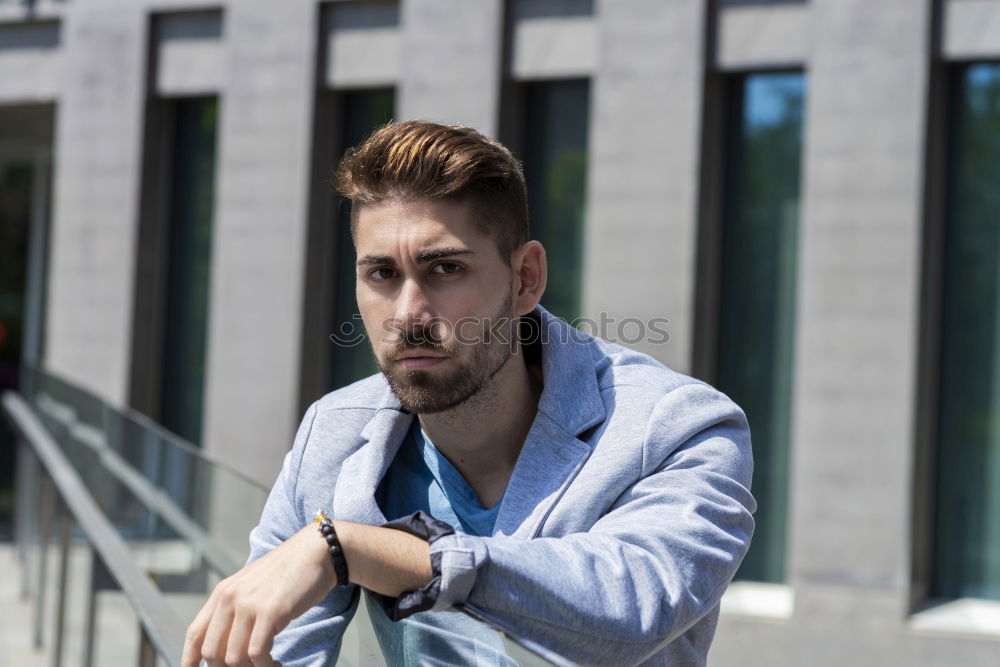 Similar – Young bearded man in urban background wearing casual clothes while leaning on a wall and looking at camera