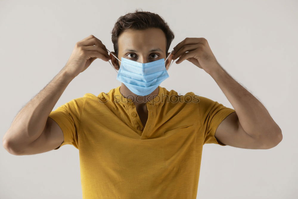 Man with facial mask and sunglasses looking at camera