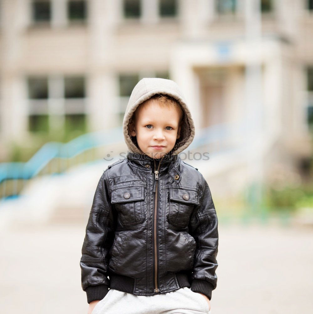 Little boy with a mibile phone with a wooden door background