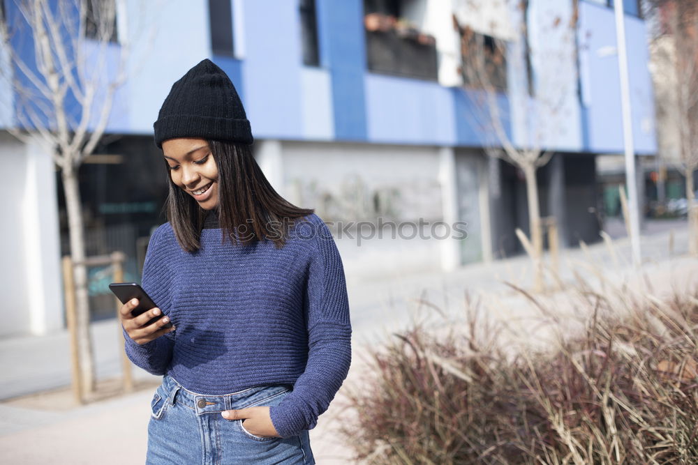 Similar – Happy woman with hat in city street, while using technology