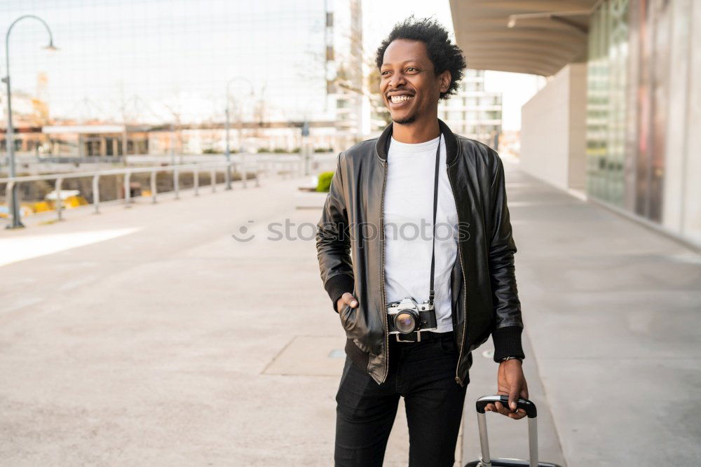 Afro young man using mobile phone and fixed gear bicycle.