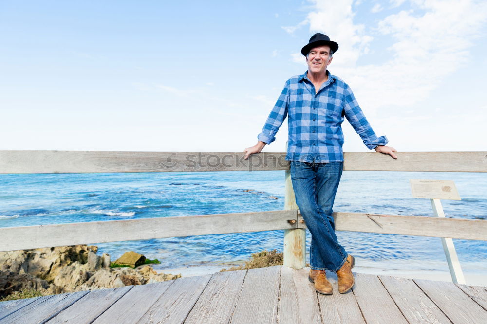 Similar – Man with tattoos holding skateboard at shore. Back view.