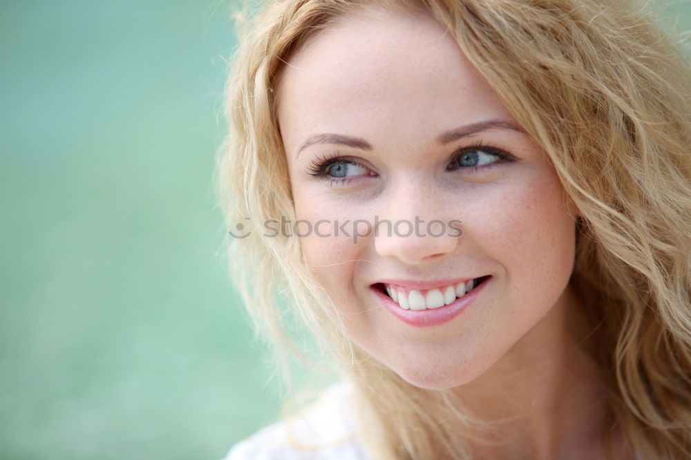 young beautiful redhead woman with curls and freckles smiles at camera