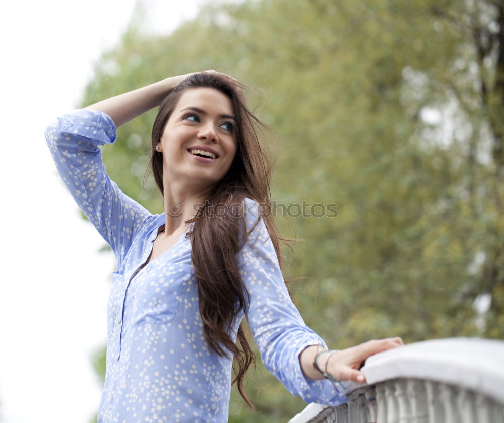 Similar – Brunette woman leaning on handrail at river