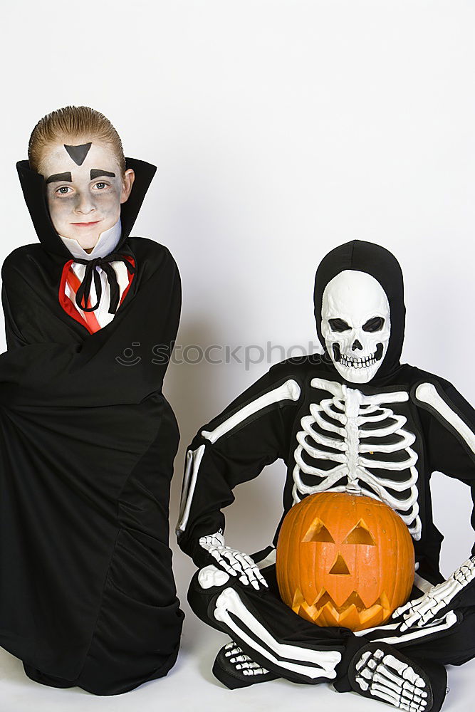 Image, Stock Photo Happy children disguised decorating a pumpkin at home.