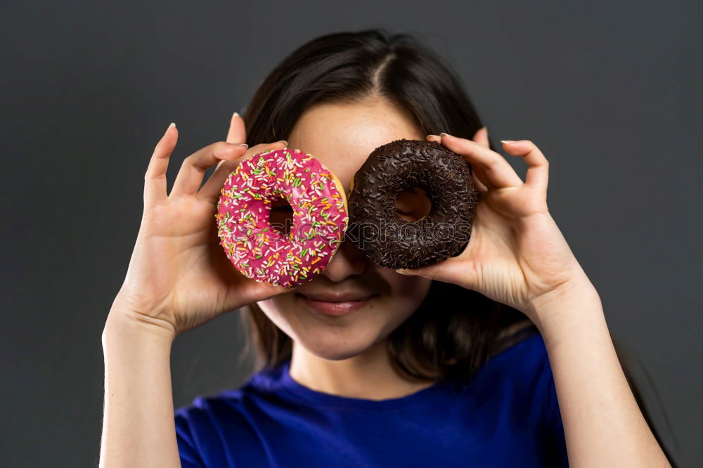 Similar – Young woman pulling funny face holding donuts in hands