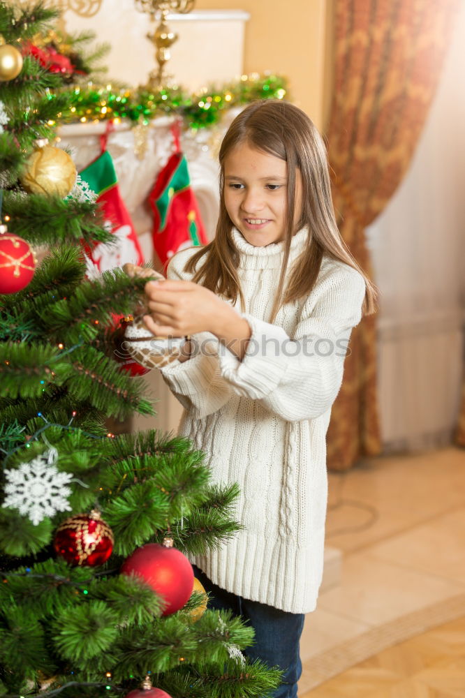 Similar – Young girl and her little sister decorating Christmas tree