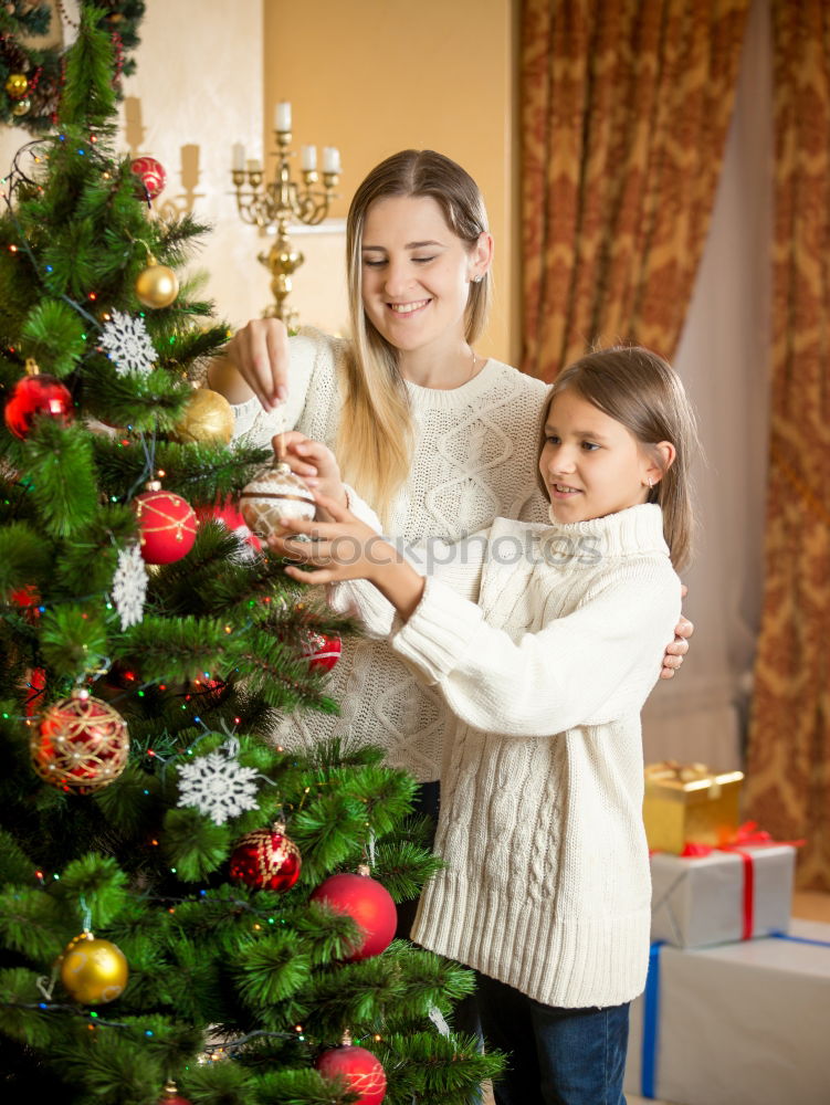 Similar – Young girl and her little sister decorating Christmas tree