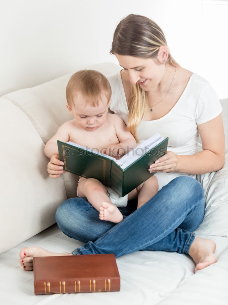 Similar – Mom reading a book her little daughter