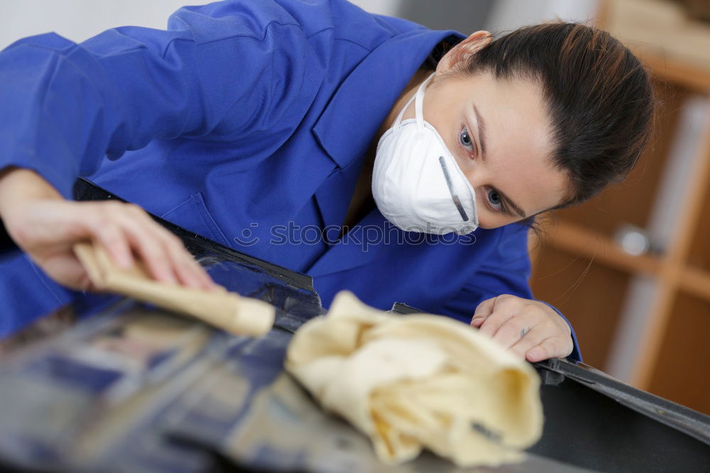 Similar – Man with a dust mask and goggles working on a circular saw