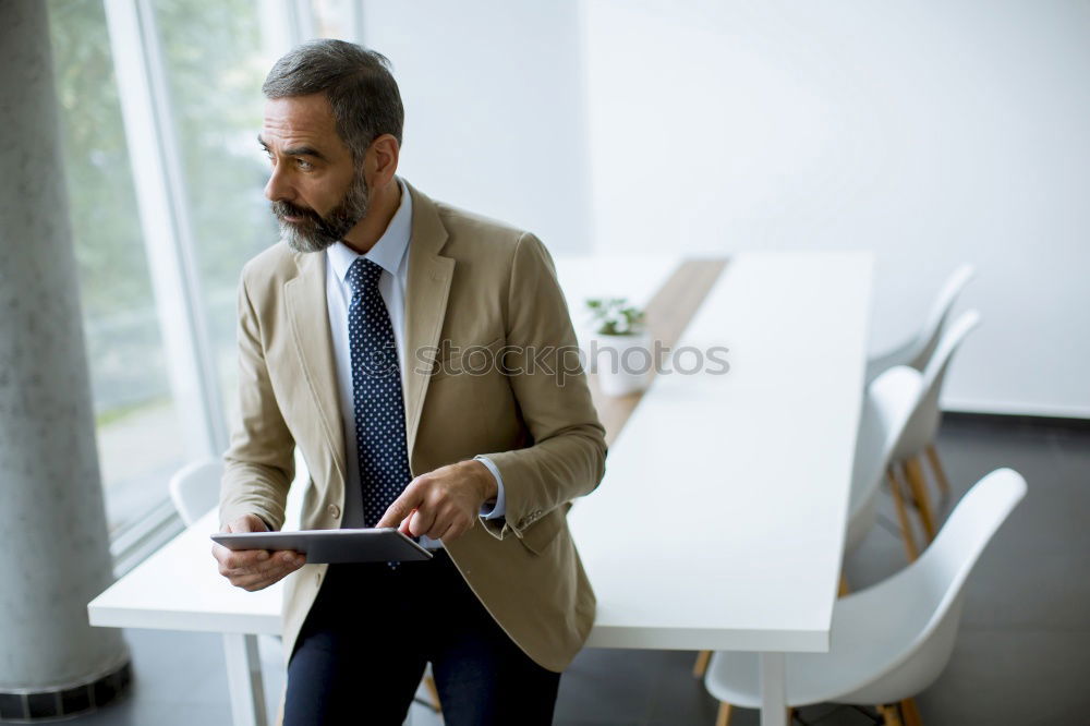 Similar – Geschäftsmann mit Blick auf das Smartphone im modernen Firmenbüro.