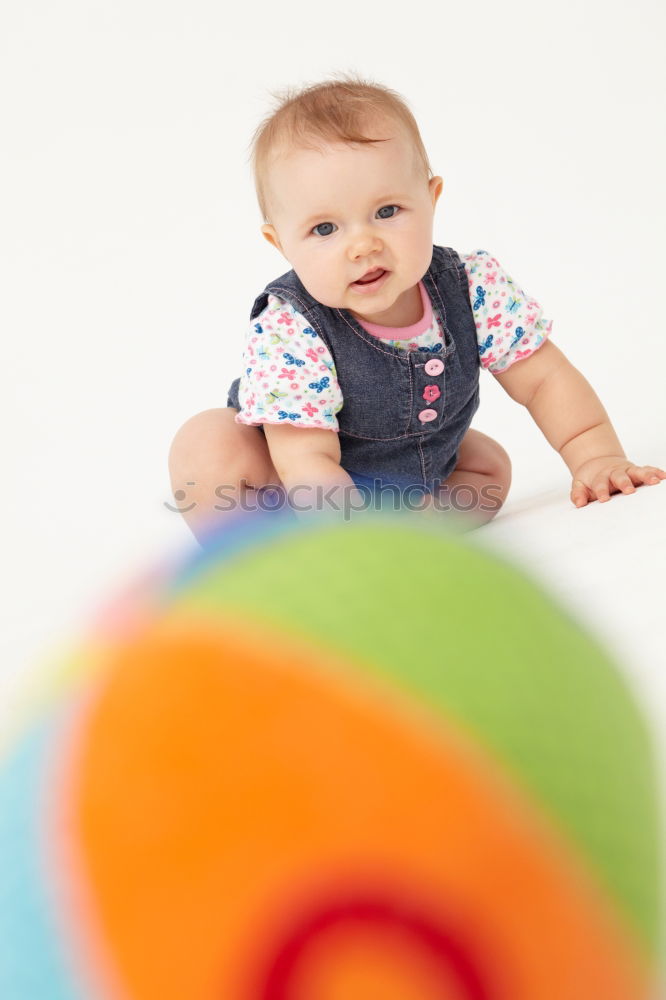 Baby girl in a bed with toys around.