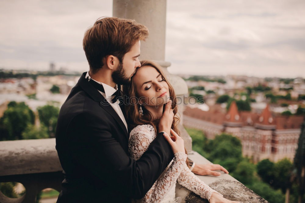Similar – Image, Stock Photo Couple hugging each other on rooftop. Girl kissing guys forehead