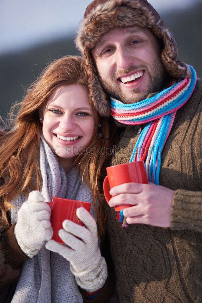 Similar – Young couple under blanket having hot drink in a cold day