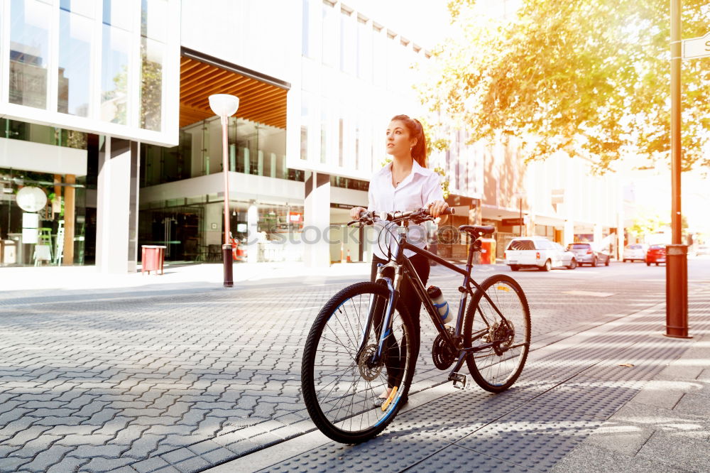 A young stylish man posing next to his bicycle.