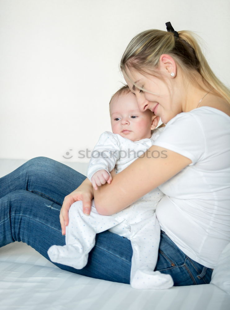 Similar – happy young mother and her baby boy lying on bed and smiling