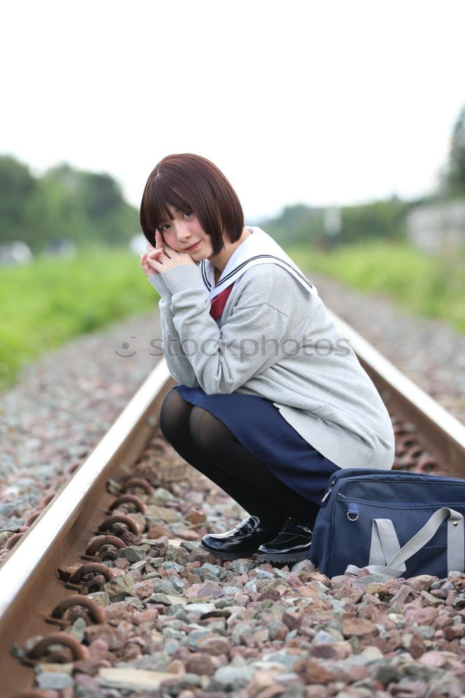 Similar – Sad girl teenager sitting on rusty rail track outside the town. Escape to be alone