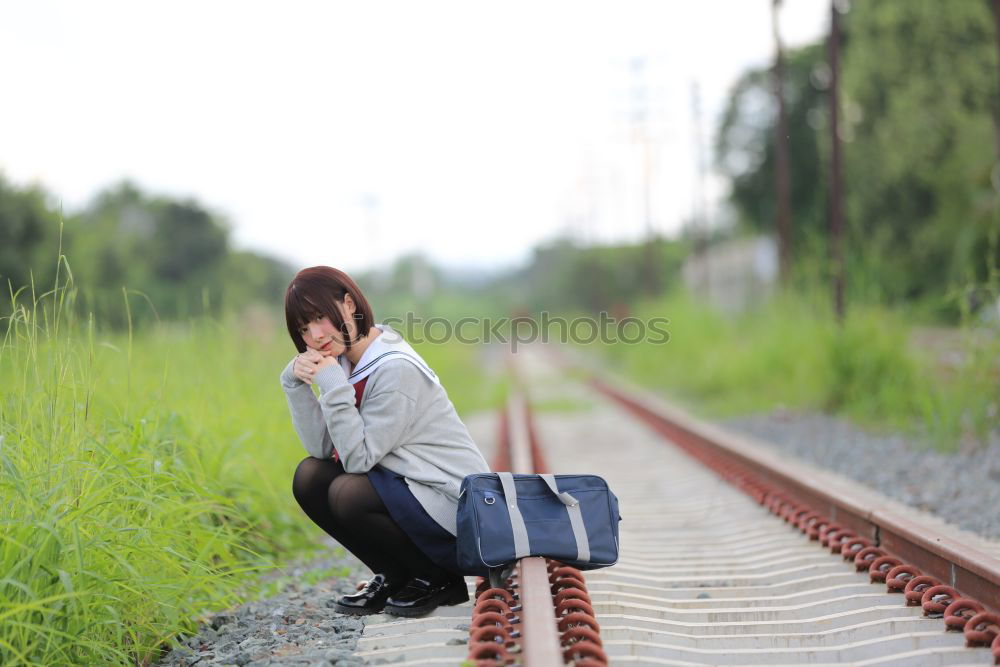 Similar – Sad girl teenager sitting on rusty rail track outside the town. Escape to be alone