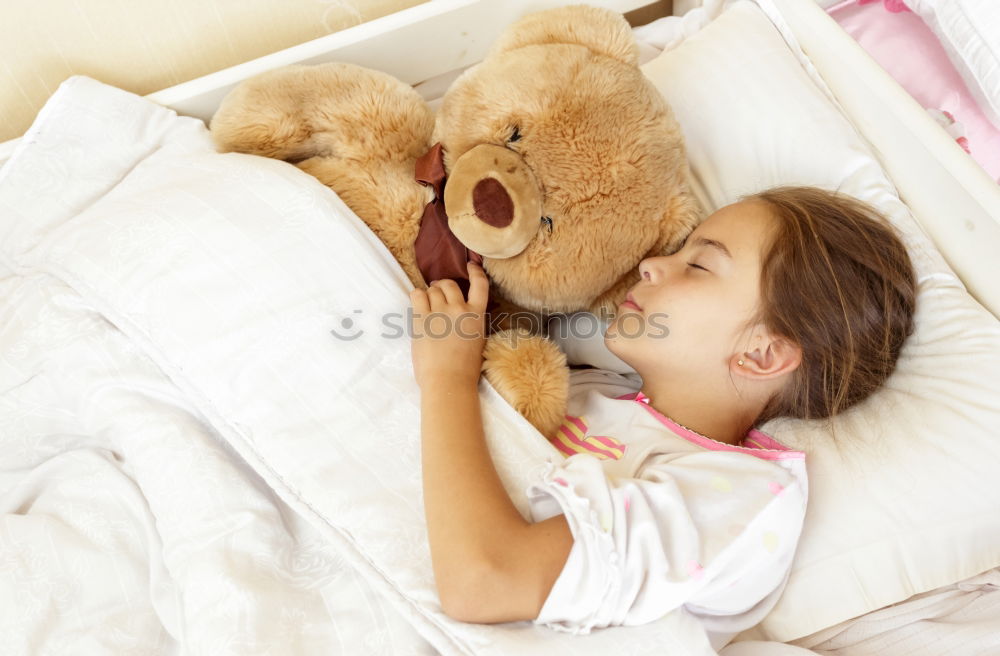 Similar – Little girl lying in a bed with teddy bear at the morning