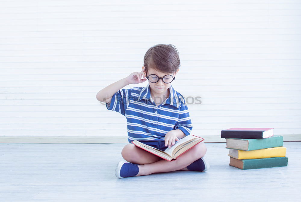 Similar – Schoolgirl reading a book in classroom