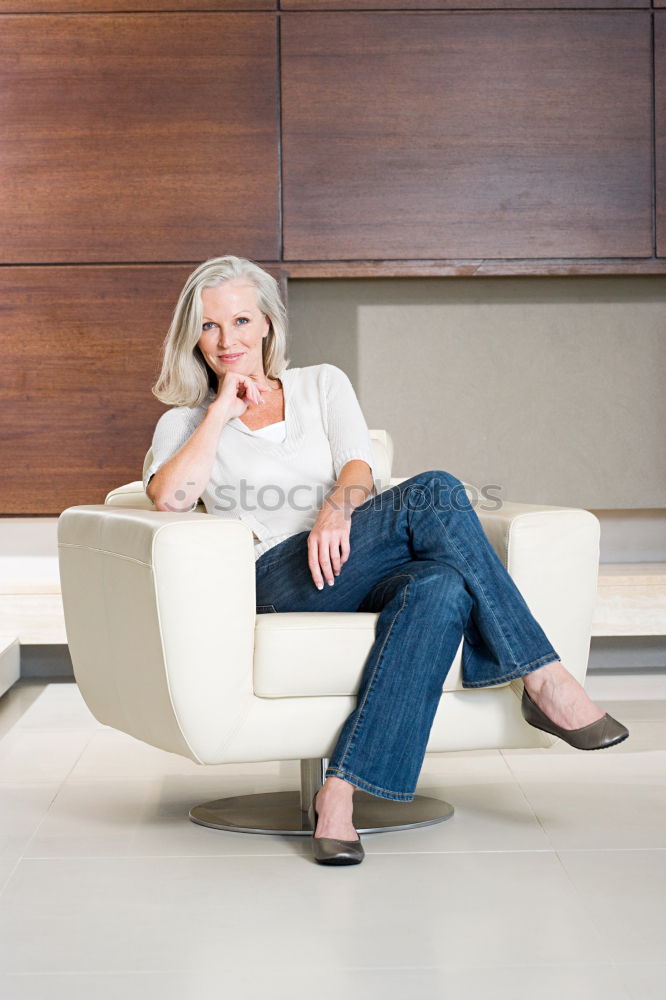 Similar – Young woman sits on the couch and sticks out one leg