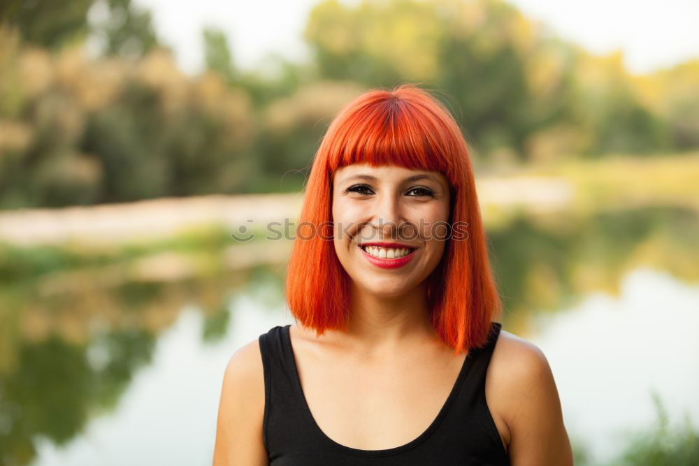 Redhead woman with blue shirt in a beautiful park