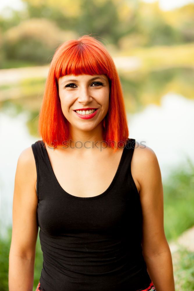 Similar – Redhead woman smelling a flower in a park