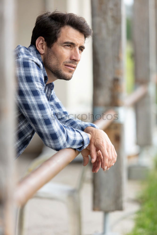 Thoughtful man with lost look near a window in a modern pub