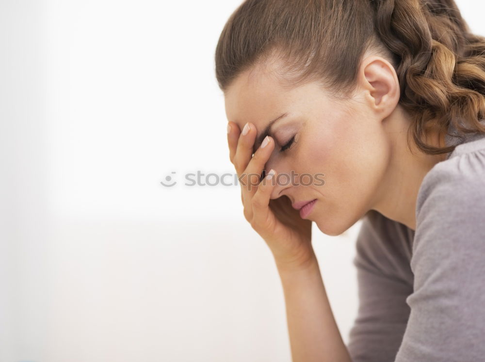 Similar – one sad woman sitting near a wall and holding her head in her hands