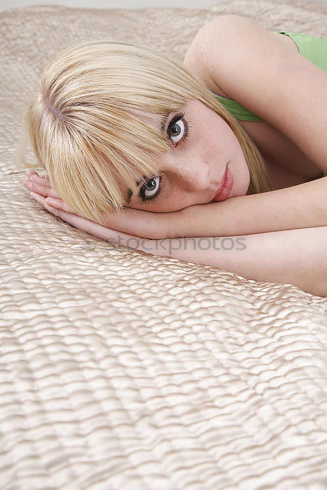 Similar – Young woman sits barefoot in undershirt on a flowered couch and looks sideways into the camera