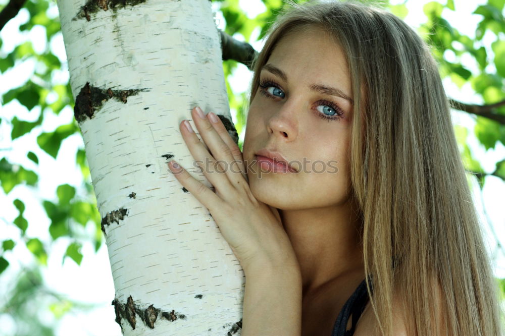 Similar – sad young woman leaning against tree