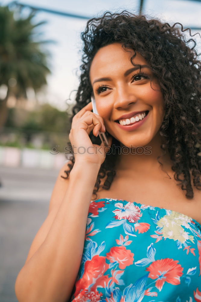 Smiling young adult woman talking on the phone