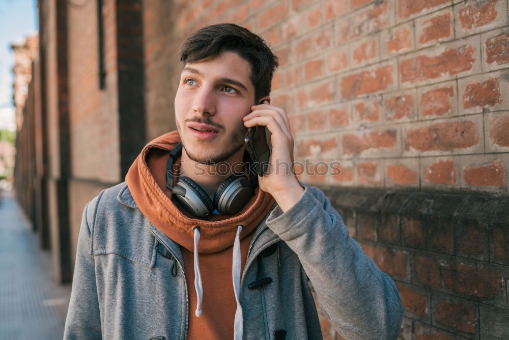 Similar – Young bearded man, model of fashion, in urban background wearing casual clothes while leaning on a wall and looking aside