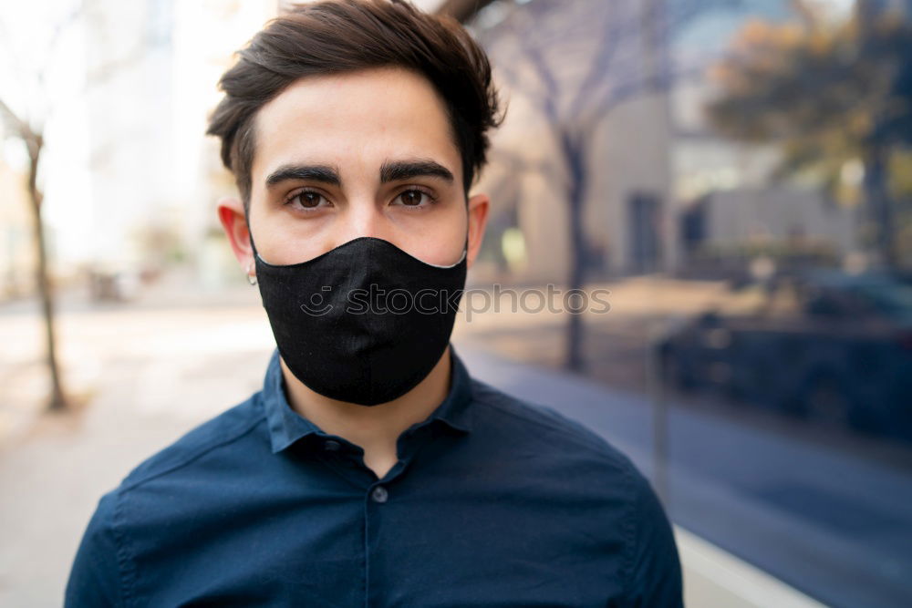 Young man standing in the city center wearing the face mask to avoid virus infection