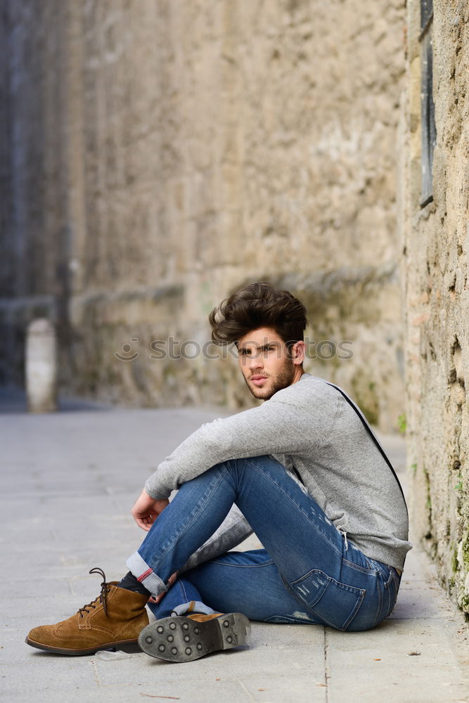 Young man sitting on the floor in urban background