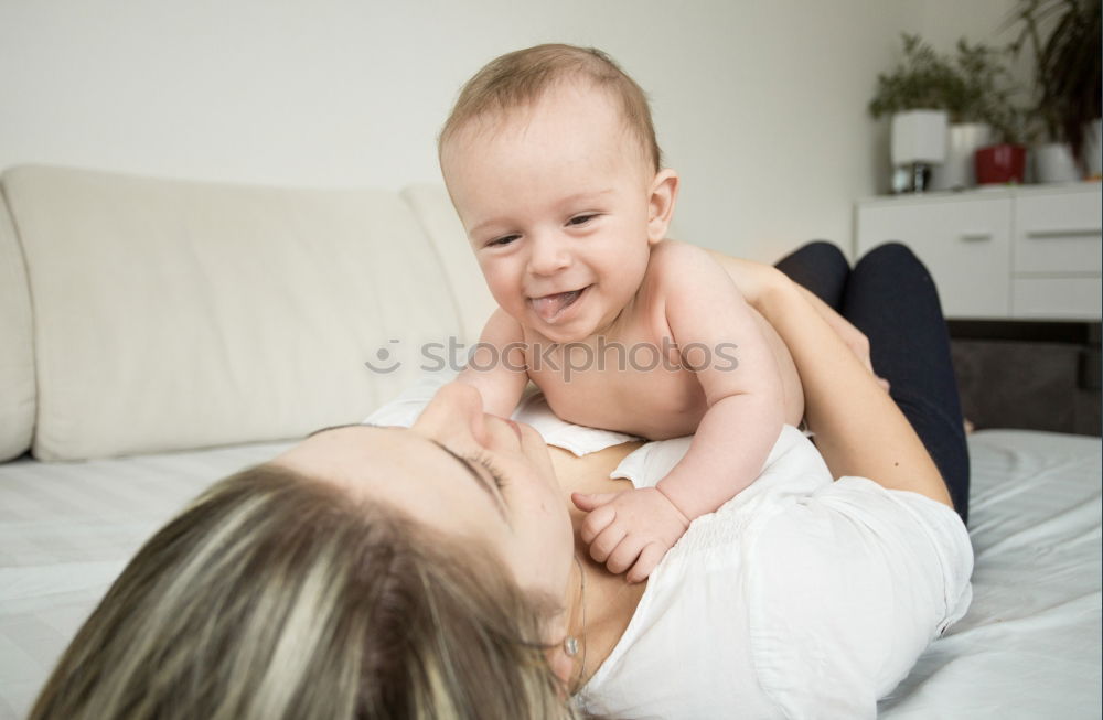 Similar – happy young mother and her baby boy lying on bed and smiling