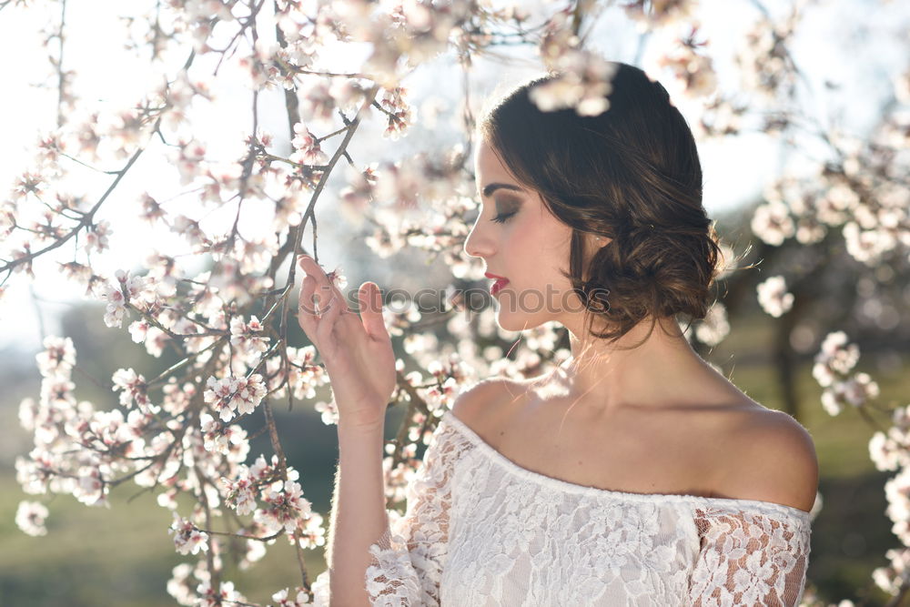 Young woman smelling almond flowers in springtime