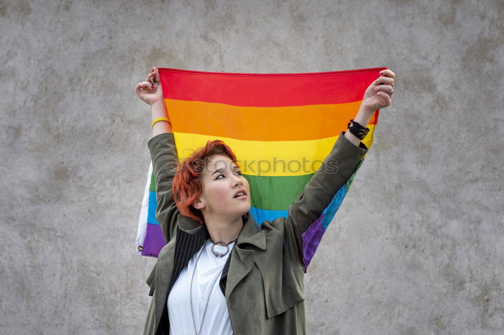 Similar – Image, Stock Photo Young woman holding a rainbow flag behind a fence