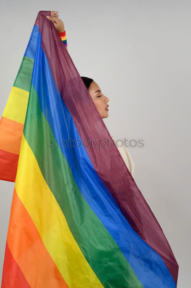 Similar – Image, Stock Photo Young woman holding a rainbow flag behind a fence