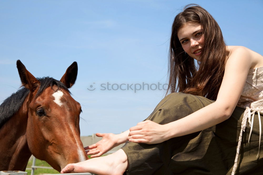 Similar – Young dark-haired curly woman with horse in stable