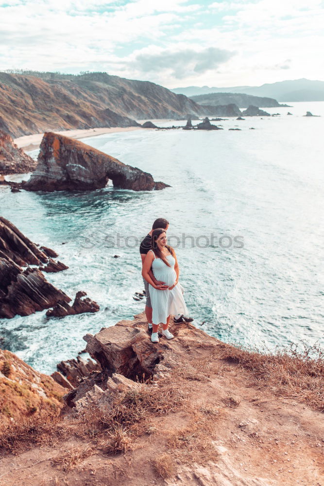 Similar – Girl with arms raised standing on the cliff