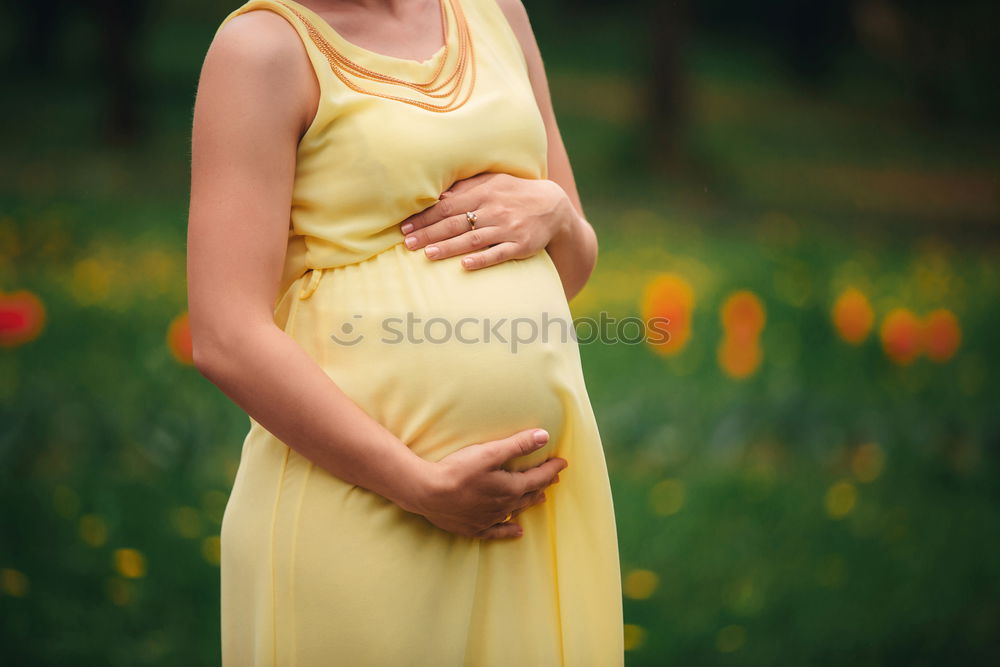 Image, Stock Photo Closeup shot of bare belly of pregnant woman. She’s holding a flower by it.